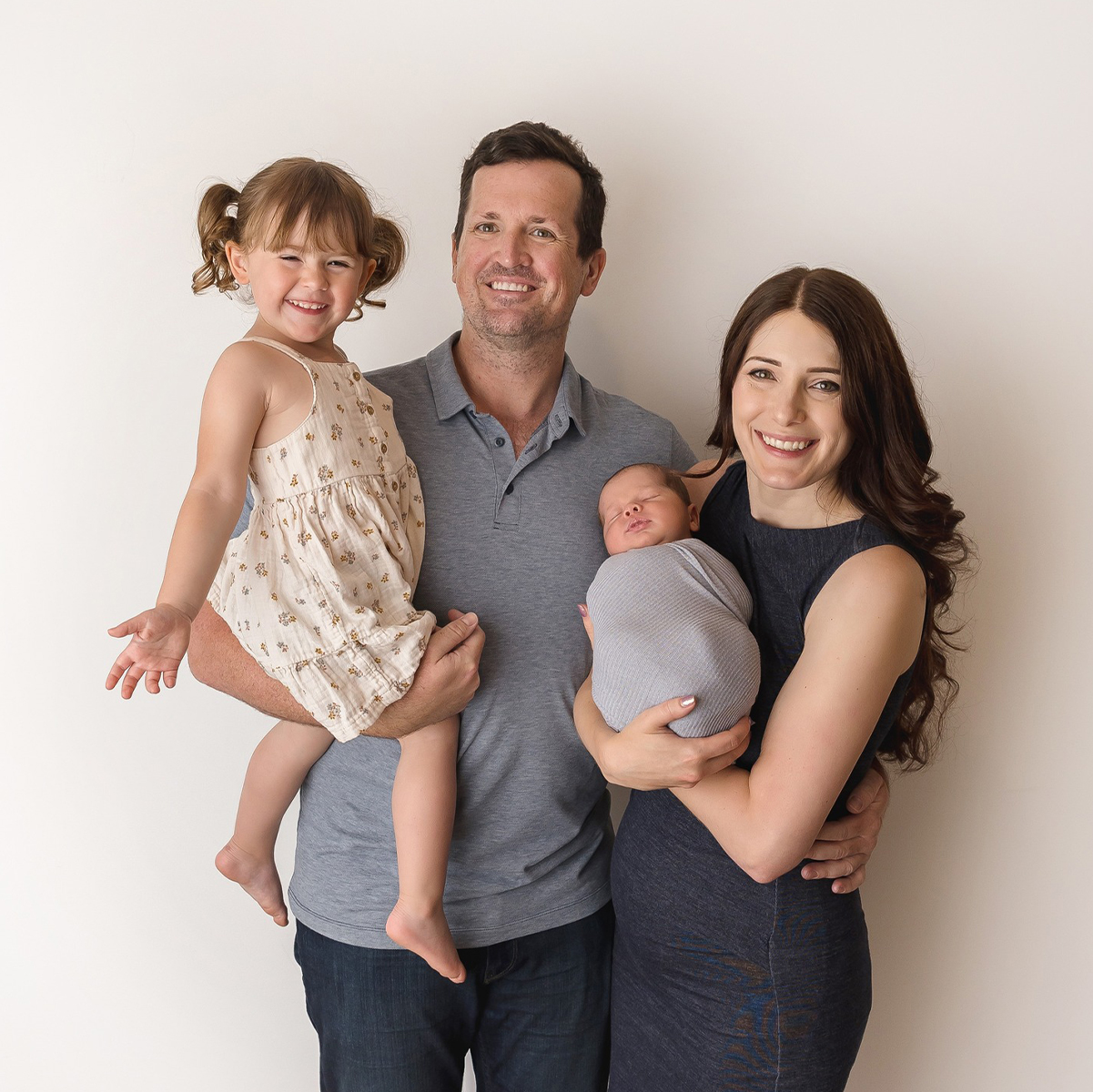 Family portrait with parents holding their newborn baby during a professional photography session in Victoria BC